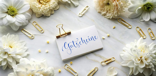 Blumen auf Tisch mit Gutschein von Juwelier Schroll in Kitzbühel