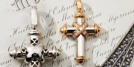 Zwei elegante Leo Wittwer Kreuzanhänger liegen auf edlem Papier. Die detailreich gearbeiteten Schmuckstücke aus hochwertigen Materialien spiegeln meisterhafte Handwerkskunst wider. Erhältlich bei Juwelier Schroll in Kitzbühel.