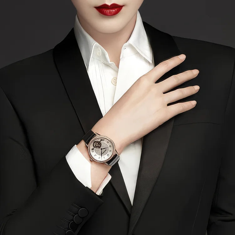 Eine elegante Frau in einem schwarzen Smoking-Blazer präsentiert eine hochwertige Vacheron Constantin Égérie Armbanduhr in Roségold mit dunklem Lederarmband. Exklusive Zeitmesser finden Sie im juwelier-tirol.shop.