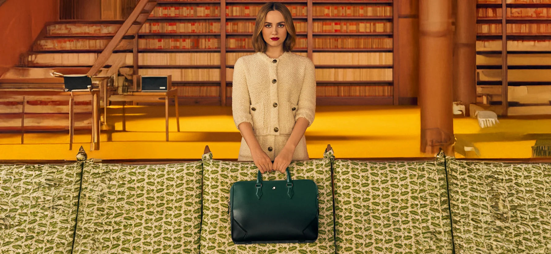 Die Schauspielerin Maude Apatow präsentiert in einem Wes-Anderson-inspirierten Setting die Montblanc Meisterstück Dokumententasche in British Green. Erhältlich im juwelier-tirol.shop.